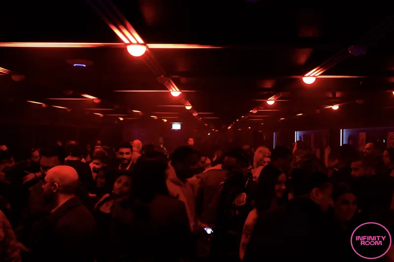 The main floor packed with people under deep red light.